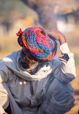 Téléchargez les photos : Pushkar, Rajasthan, India - November 2022: Pushkar Fair, Portrait of an camel trader in ethnic dress and rajasthani turban on fair ground during pushkar fair. - en image libre de droit