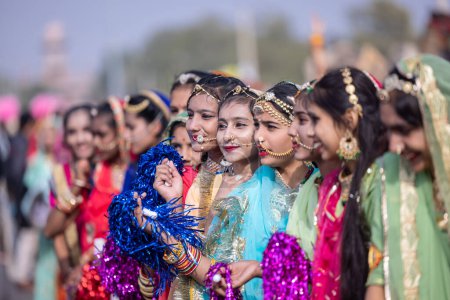 Photo for Bikaner, Rajasthan, India - January 2023: Camel Festival Bikaner, Group of young beautiful girls in traditional dress and jewellery of rajasthan while participating in the parade. Selective focus. - Royalty Free Image