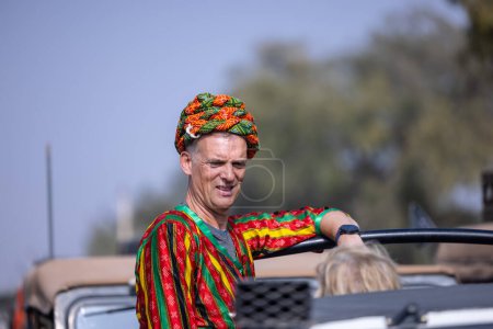 Foto de Bikaner, Rajasthan, India - January 2023: Camel Festival, Portrait of an rajasthani male with moustache, colorful turban wearing traditional colorful rajasthani dress. Rajput male of bikaner. - Imagen libre de derechos
