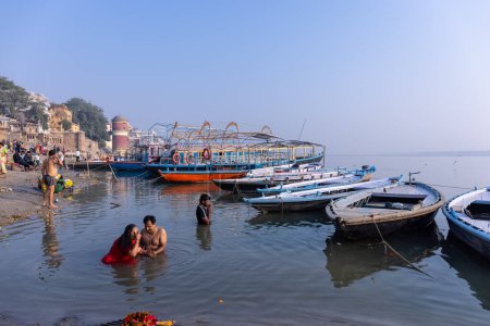 Photo for Varanasi, Uttar Pradesh, India - November 2022: Numerous country wooden boats and vintage historical mansions near river ganges. - Royalty Free Image