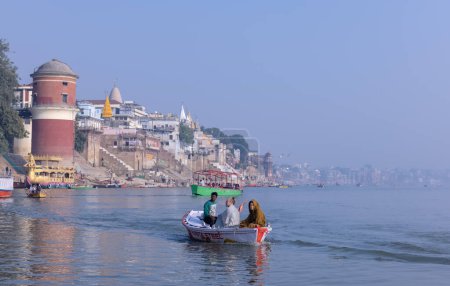 Téléchargez les photos : Varanasi, Uttar Pradesh, Inde - Novembre 2022 : Les touristes profitent d'une promenade en bateau dans les chaînes fluviales avec le troupeau de goélands marins à varanasi tôt le matin. Bateau naviguant sur le bateau en bois. - en image libre de droit
