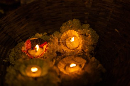 Diya-Kerzen, die in der Nacht in Flussgängen treiben. Selektiver Fokus auf die Flamme.