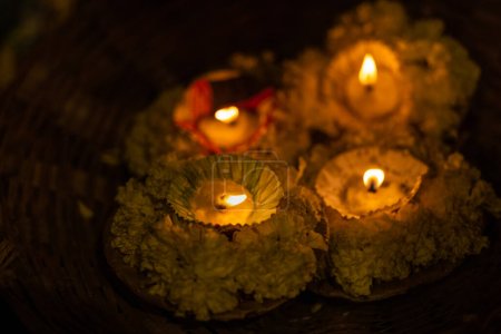 Diya candles floating in river ganges during night. Selective focus on flame.