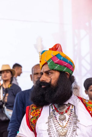 Téléchargez les photos : Pushkar, Rajasthan, Inde - Novembre 2022 : Foire de Pushkar, portrait d'un homme rajasthani rajput avec barbe et moustache portant une robe traditionnelle colorée rajasthani et turban au terrain de foire pushkar. - en image libre de droit
