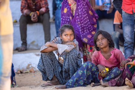 Téléchargez les photos : Pushkar, Rajasthan, Inde - Novembre 2022 : Foire de Pushkar, Portrait de jeunes enfants sur un terrain de foire en robes colorées regardant les activités pendant la foire. - en image libre de droit