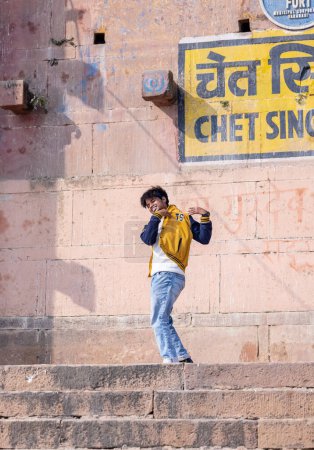 Foto de Varanasi, Uttar Pradesh, India - Noviembre de 2022: Retrato de un joven practicando danza en ghats cerca de bandas fluviales en varanasi. Ghats en varanasi es testigo de muchas prácticas y demostraciones de obras de arte. - Imagen libre de derechos