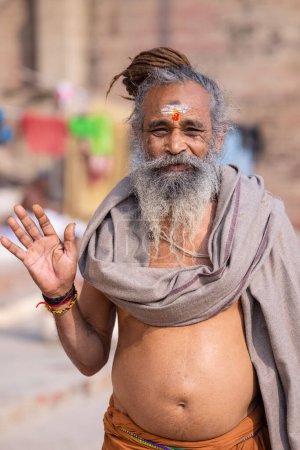 Foto de Varanasi, Uttar Pradesh, India - 20 de noviembre de 2022: Retrato de un hombre sadhu sagrado indio no identificado en ghats cerca de las bandas fluviales en la ciudad de varanasi con vestimenta tradicional. - Imagen libre de derechos