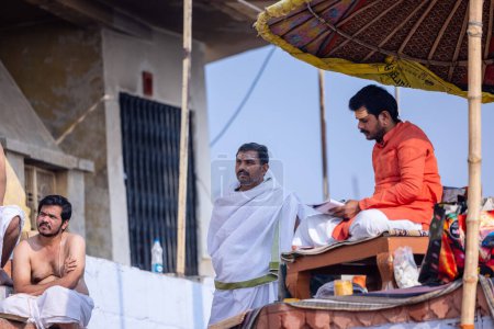 Photo for Varanasi, Uttar Pradesh, India - November 20 2022: Portrait of Unidentified Indian holy brahmin male priest sittings on kedar ghat near river ganges in varanasi city in traditional dress - Royalty Free Image