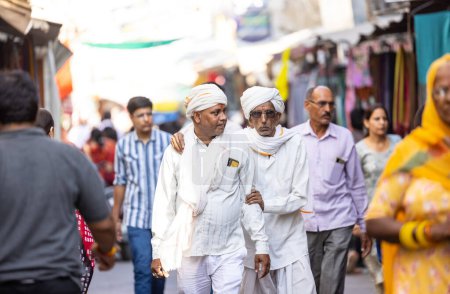 Téléchargez les photos : Pushkar, Rajasthan, Inde - 05 novembre 2022 : Foire de Pushkar, Portrait d'un vieux marathi avec robe blanche traditionnelle blanche et chapeau blanc marchant au marché de pushkar. - en image libre de droit