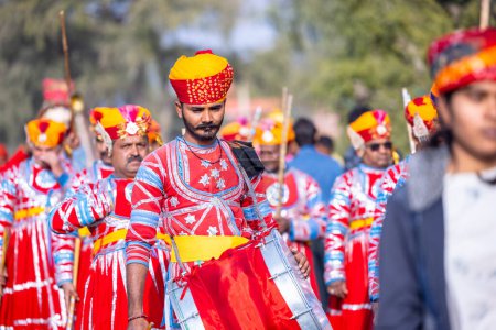Téléchargez les photos : Bikaner, Rajasthan, Inde - 13 janvier 2023 : Festival du chameau, groupe d'artistes masculins rajasthani jouant de l'instrument de musique avec un turban coloré portant une robe rajasthani colorée traditionnelle. - en image libre de droit