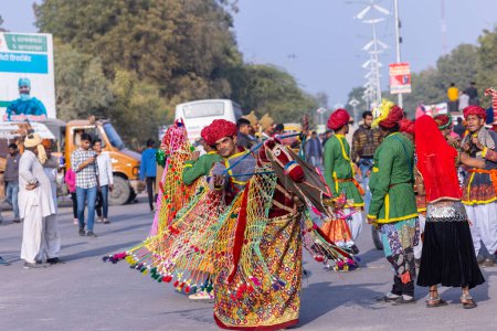 Téléchargez les photos : Bikaner, Rajasthan, Inde - 13 janvier 2023 : Festival du chameau, Portrait d'un artiste masculin rajasthani exécutant la danse du cheval en tenue traditionnelle dans les rues de bikaner pendant le défilé. - en image libre de droit
