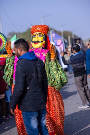 Téléchargez les photos : Bikaner, Rajasthan, Inde - 13 janvier 2023 : Festival du chameau, Portrait d'un artiste masculin en tant que personnage de marionnette indien coloré tout en participant au défilé du festival du chameau au bikaner. Concentration sélective. - en image libre de droit