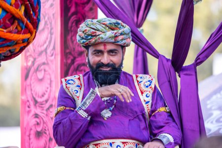 Téléchargez les photos : Bikaner, Rajasthan, Inde - 13 janvier 2023 : Festival du chameau, Portrait d'un jeune homme rajasthani avec barbe et moustache portant une robe traditionnelle blanche rajasthani et turban. - en image libre de droit