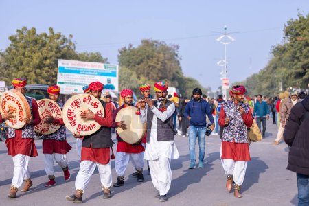 Téléchargez les photos : Bikaner, Rajasthan, Inde - 13 janvier 2023 : Festival du chameau, Portrait d'un artiste masculin rajasthani jouant de l'instrument de musique avec un turban coloré portant une robe rajasthani colorée traditionnelle. - en image libre de droit