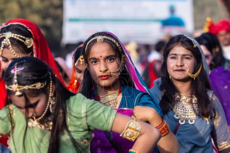 Foto de Bikaner, Rajastán, India - 13 de enero de 2023: Festival de Camellos Bikaner, Grupo de jóvenes hermosas con vestido tradicional rajastaní y joyas mientras participaban en el desfile. Enfoque selectivo. - Imagen libre de derechos