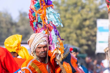 Téléchargez les photos : Bikaner, Rajasthan, Inde - 13 janvier 2023 : Festival du chameau, Portrait d'un artiste masculin rajasthani jouant de l'instrument de musique avec un turban coloré portant une robe rajasthani colorée traditionnelle. - en image libre de droit