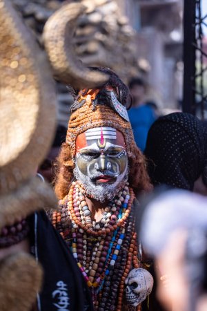 Téléchargez les photos : Varanasi, Uttar Pradesh, Inde - 03 mars 2023 : Masan Holi, Portrait d'un artiste masculin au visage peint agissant comme shiva de seigneur lors de la célébration de masaan holi au harishchandra ghat à varanasi. - en image libre de droit