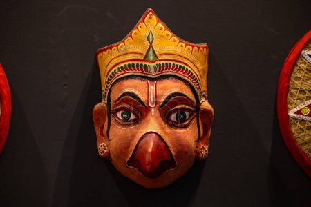 Foto de Hecho a mano colorido aspecto tribal máscara de recuerdo colgando en el fondo llano. Enfoque selectivo en el objeto. - Imagen libre de derechos
