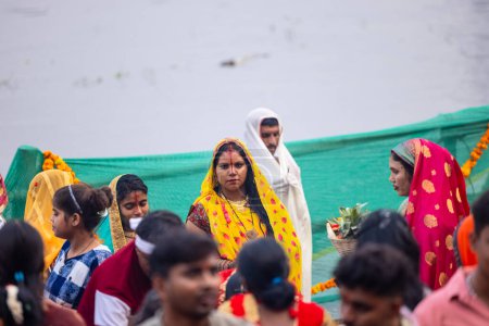Foto de Ghaziabad, Uttar Pradesh, India - 30 de octubre de 2022: Chhas Puja, devota hindú india que realiza rituales de chhas puja mientras está de pie en el río para adorar al Señor Sol durante la puesta del sol. - Imagen libre de derechos