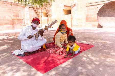 Téléchargez les photos : Jodhpur, Rajasthan, Inde - 25 septembre 2021 : Mehrangarh Fort, Portrait de l'artiste jouant de l'instrument de musique dans la robe traditionnelle Rajasthani pour divertir les touristes dans les locaux du fort. - en image libre de droit