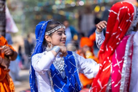 Foto de Faridabad, Haryana, India - 4 de febrero de 2023: Hermosas niñas bailando con vestimenta étnica y joyas de haryana durante la feria de artesanía surajkund. - Imagen libre de derechos