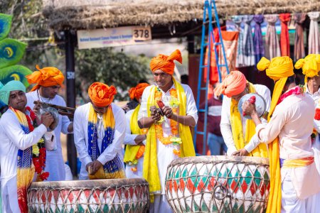 Foto de Faridabad, Haryana, India - 4 de febrero de 2023: Retrato de artistas masculinos de haryana tocando instrumentos musicales durante la feria de artesanía surajkund para entretener a los turistas. - Imagen libre de derechos