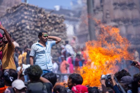 Foto de Varanasi, Uttar Pradesh, India - 04 de marzo de 2023: Masan Holi, Grupo de personas no identificadas que celebra el festival de holi en Manikarnika ghat con fuego ardiente en el fondo. - Imagen libre de derechos