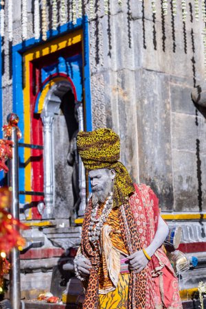 Photo for Kedarnath, Uttarakhand, India - October 15 2022: Portrait of an old naga sadhu baba in traditional dress and ashes on face outside the holy temple of baba kedarnath. - Royalty Free Image