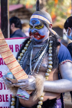 Foto de Faridabad, Haryana, India - 04 de febrero de 2023: Retrato de un artista indio masculino con una cara pintada de colores como personaje histórico durante la feria de artesanía surajkund para atraer turistas. - Imagen libre de derechos
