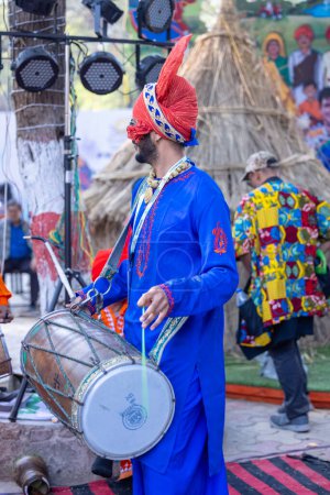 Foto de Faridabad, Haryana, India - 04 de febrero de 2023: Retrato de un sikh masculino con ropa punjabi tradicional y turbante durante una actuación de danza bhangra con sonrisa en la feria de artesanía surajkund - Imagen libre de derechos
