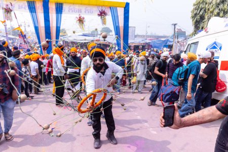 Foto de Anandpur Sahib, Punjab, India - 19 de marzo de 2022: Retrato del hombre sikh (Nihang Sardar) realizando arte marcial como cultura durante la celebración de Hola Mohalla en Anandpur Sahib durante el festival holi. - Imagen libre de derechos
