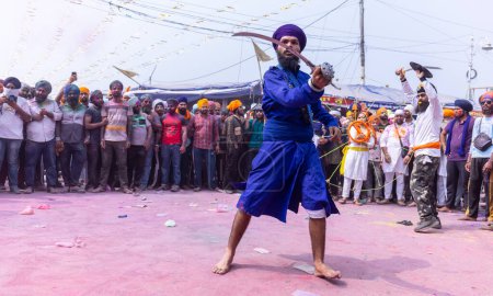 Téléchargez les photos : Anandpur Sahib, Punjab, Inde - 19 mars 2022 : Portrait d'hommes sikhs (Nihang Sardar) exécutant des arts martiaux en tant que culture lors de la célébration de Hola Mohalla à Anandpur Sahib pendant le festival holi - en image libre de droit
