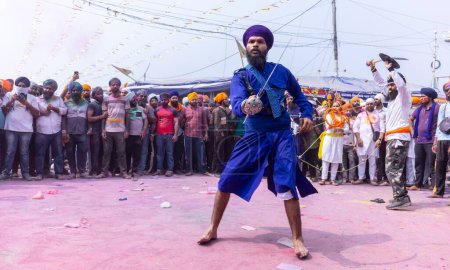 Foto de Anandpur Sahib, Punjab, India - 19 de marzo de 2022: Retrato de hombres sikh (Nihang Sardar) realizando arte marcial como cultura durante la celebración de Hola Mohalla en Anandpur Sahib durante el festival holi - Imagen libre de derechos