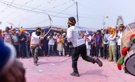 Foto de Anandpur Sahib, Punjab, India - 19 de marzo de 2022: Retrato de hombres sikh (Nihang Sardar) realizando arte marcial como cultura durante la celebración de Hola Mohalla en Anandpur Sahib durante el festival holi - Imagen libre de derechos