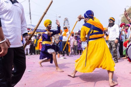 Téléchargez les photos : Anandpur Sahib, Punjab, Inde - 19 mars 2022 : Portrait d'un homme sikh (Nihang Sardar) pratiquant l'art martial en tant que culture lors de la célébration de Hola Mohalla à Anandpur Sahib pendant le festival holi - en image libre de droit