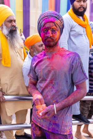 Foto de Anandpur Sahib, Punjab, India - 19 de marzo de 2022: Grupo de hombres sikh (Nihang Sardar) durante la celebración de Hola Mohalla en Anandpur Sahib durante el festival holi. Enfoque selectivo en la cara colorida. - Imagen libre de derechos