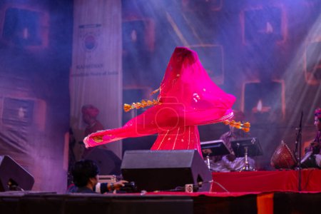 Photo for Pushkar, Rajasthan, India - November 05, 2022: Portrait of female artist performing rajasthani folk dance Ghoomar with veil in traditional colorful dress in Pushkar fair - Royalty Free Image