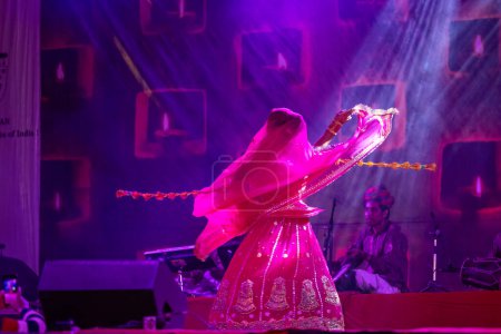 Photo for Pushkar, Rajasthan, India - November 05, 2022: Portrait of female artist performing rajasthani folk dance Ghoomar with veil in traditional colorful dress in Pushkar fair - Royalty Free Image