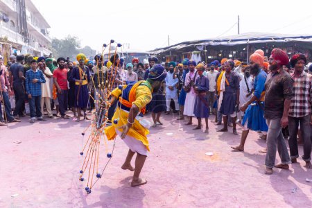 Téléchargez les photos : Anandpur Sahib, Punjab, Inde - 19 mars 2022 : Portrait d'un homme sikh (Nihang Sardar) jouant de l'art martial en tant que culture lors de la célébration de Hola Mohalla à Anandpur Sahib pendant le festival holi - en image libre de droit