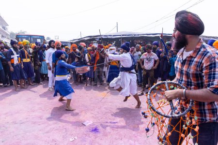 Téléchargez les photos : Anandpur Sahib, Punjab, Inde - 19 mars 2022 : Portrait d'hommes sikhs (Nihang Sardar) exécutant des arts martiaux en tant que culture lors de la célébration de Hola Mohalla à Anandpur Sahib pendant le festival holi - en image libre de droit