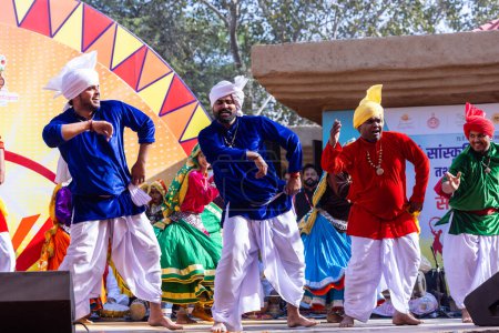 Foto de Faridabad, Haryana, India - 04 de febrero de 2023: Retrato de artistas masculinos y femeninos de haryana mientras realizan la danza folclórica con vestidos étnicos en la feria de artesanía surajkund - Imagen libre de derechos