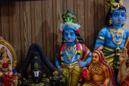 Téléchargez les photos : Sculpture du Dieu indien Krishna faite à la main souvenir fait avec de l'argile avec un fond clair. Concentration sélective - en image libre de droit
