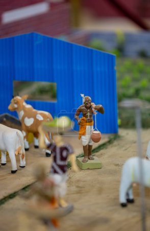 Handmade cows and farmer on farming field made with clay. Selective focus.
