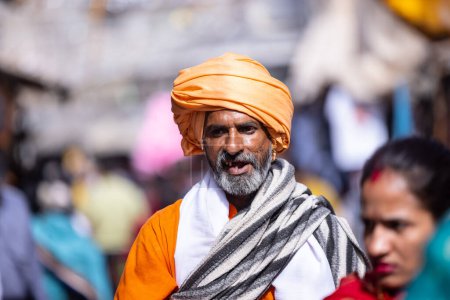 Téléchargez les photos : Pushkar, Rajasthan, Inde - 06 Novembre 2022 : Foire de Pushkar, Portrait d'un vieil homme rajasthani avec turban coloré jouissant au terrain de foire de pushkar - en image libre de droit
