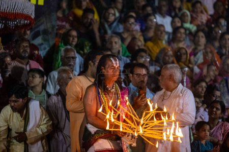 Foto de Pushkar, Rajastán, India - 06 de noviembre de 2022: Retrato de un sacerdote hindú masculino realizando maha aarti vespertino (oración) del lago sagrado de pushkar llamado sarovar en pushkar como rituales hindúes de sanatán - Imagen libre de derechos
