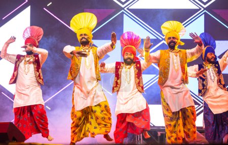 Téléchargez les photos : Bikaner, Rajasthan, Inde - 14 janvier 2023 : Groupe d'artistes punjabis du punjab exécutant la danse bhangra en vêtements traditionnels colorés au festival de chameaux bikaner - en image libre de droit