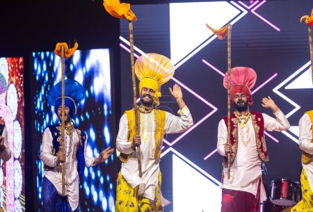 Téléchargez les photos : Bikaner, Rajasthan, Inde - 14 janvier 2023 : Groupe d'artistes punjabis du punjab exécutant la danse bhangra en vêtements traditionnels colorés au festival de chameaux bikaner - en image libre de droit