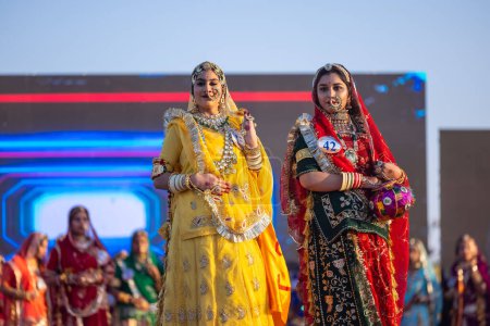 Photo for Bikaner, Rajasthan, India - January 14, 2023: Portrait of young beautiful indian women in ethnic rajasthani lehenga choli dresses participating in miss marwar fashion show during bikaner camel festival - Royalty Free Image