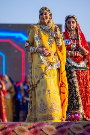 Photo for Bikaner, Rajasthan, India - January 14, 2023: Portrait of young beautiful indian women in ethnic rajasthani lehenga choli dresses participating in miss marwar fashion show during bikaner camel festival - Royalty Free Image