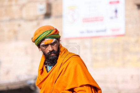 Photo for Varanasi, Uttar Pradesh, India - March 05 2023: Portrait of old holy sadhu baba in traditional dress sitting on ghats near ganges in varanasi. Kashi oldest and holy city - Royalty Free Image